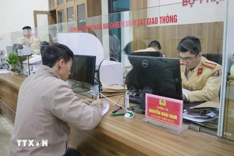 Người dân đến nộp tiền vi phạm tại một bộ phận xử lý phạt nguội qua camera giám sát giao thông. (Ảnh: Đinh Thùy/TTXVN)