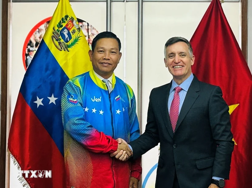 Đại sứ Vũ Trung Mỹ mặc áo đội tuyển Olympic quốc gia Venezuela do Bộ trưởng Franklin Cardillo trao tặng. (Ảnh: ĐSQ cung cấp)