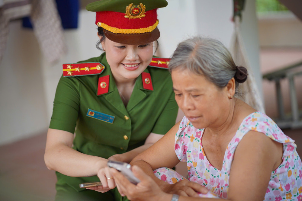 Đại úy Sầm Thị Thanh Mai hướng dẫn người dân cài đặt ứng dụng VNeID