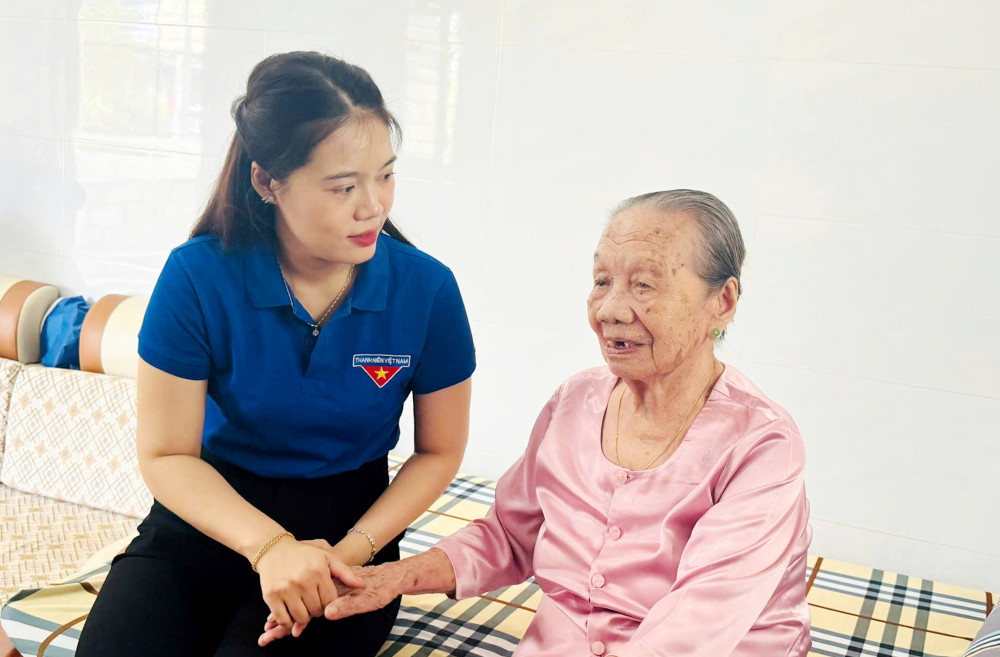 Phó Chủ tịch UBMTTQ Việt Nam phường, Bí thư Đoàn phường Tân Ninh Nguyễn Thị Kim Phú trò chuyện, thăm hỏi sức khoẻ Mẹ Việt Nam anh hùng Lê Thị Hai