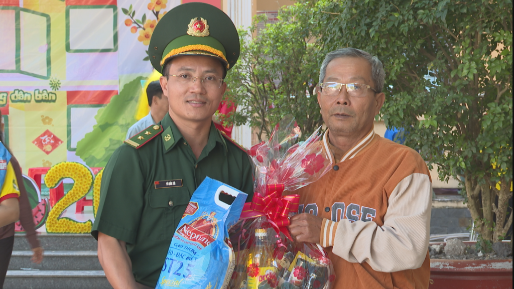 Trung tá Vũ Văn Tới - Chính trị viên Đồn Biên phòng Tống Lê Chân tặng quà cho người dân tại Chương trình