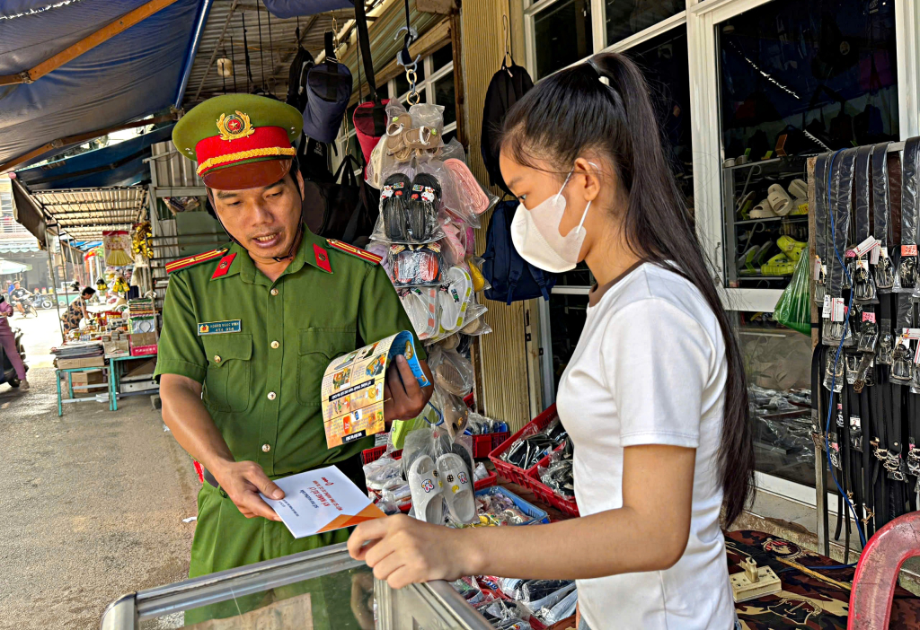 Cán bộ phát tờ rơi tuyên truyền, nhắc nhở người dân chấp hành nghiêm các quy định về phòng cháy chữa cháy