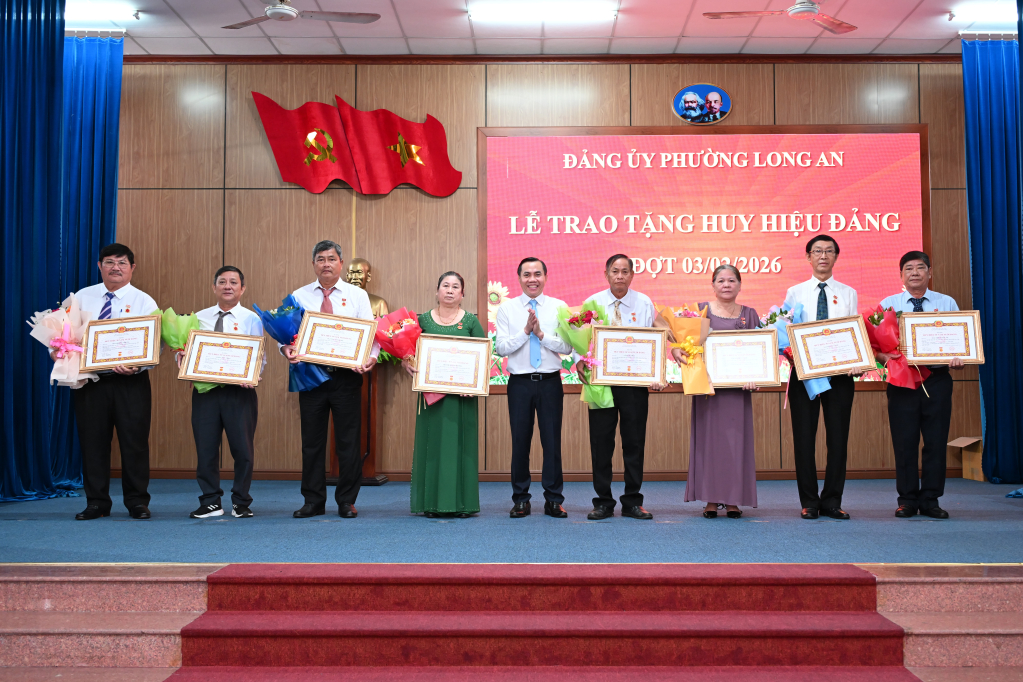 Ủy viên Ban Thường vụ Tỉnh ủy, Bí thư Đảng ủy phường Long An Lê Công Đỉnh trao tặng huy hiệu Đảng cho các đảng viên