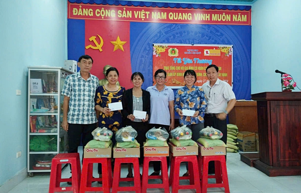 Ông Nguyễn Kim Long (bìa trái) tham gia hoạt động trao tặng quà Tết cho hộ gia đình có hoàn cảnh khó khăn