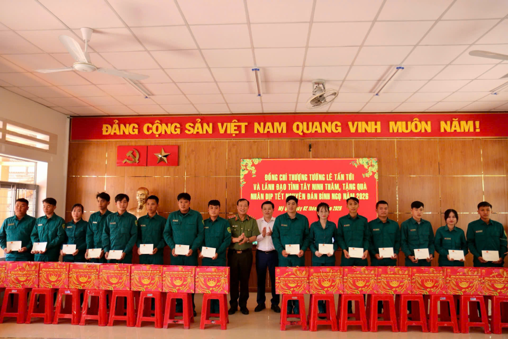 Thượng tướng Lê Tấn Tới và Chủ tịch UBMTTQVN tỉnh Nguyễn Thanh Hải (áo trắng) tặng quà cho lực lượng dân quân tại xã Mỹ Quý