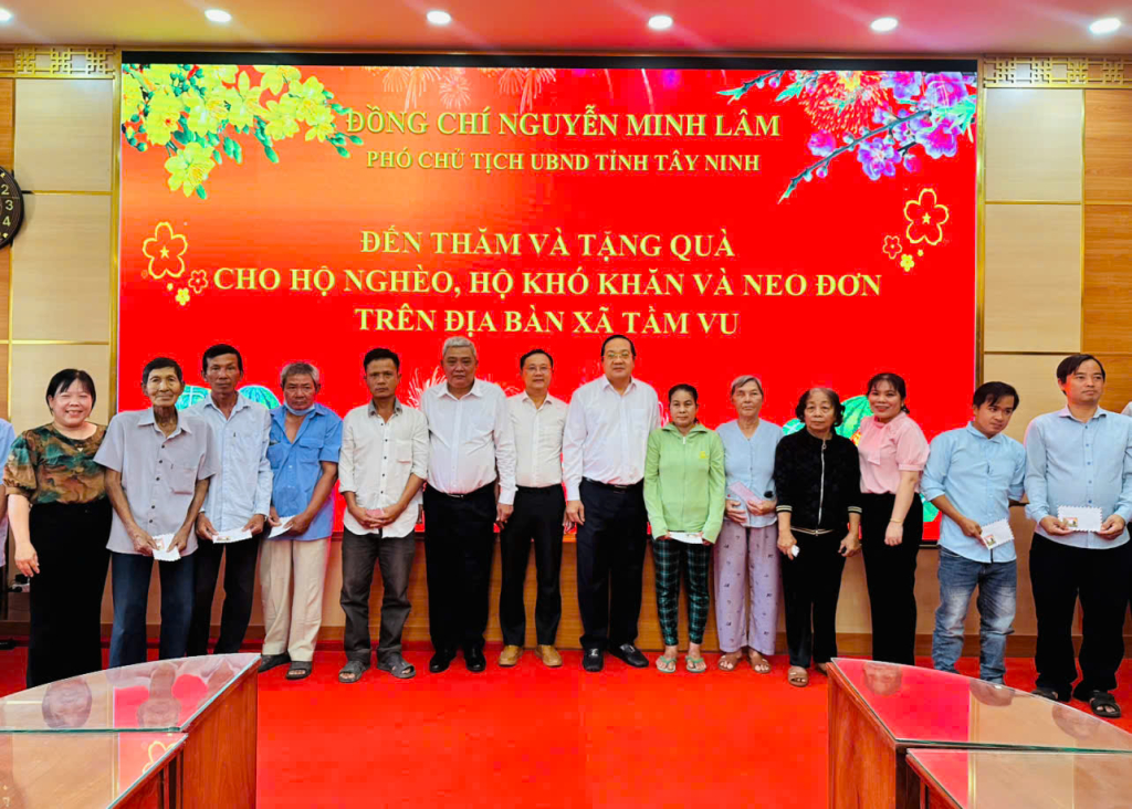 Phó Chủ tịch UBND tỉnh Tây Ninh Nguyễn Minh Lâm (thứ 7, từ phải qua) trao quà tết cho các gia đình chính sách, hộ khó khăn