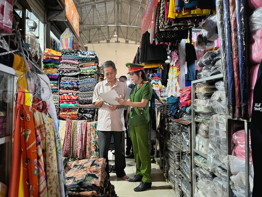 Cán bộ phát tờ rơi tuyên truyền cho người dân