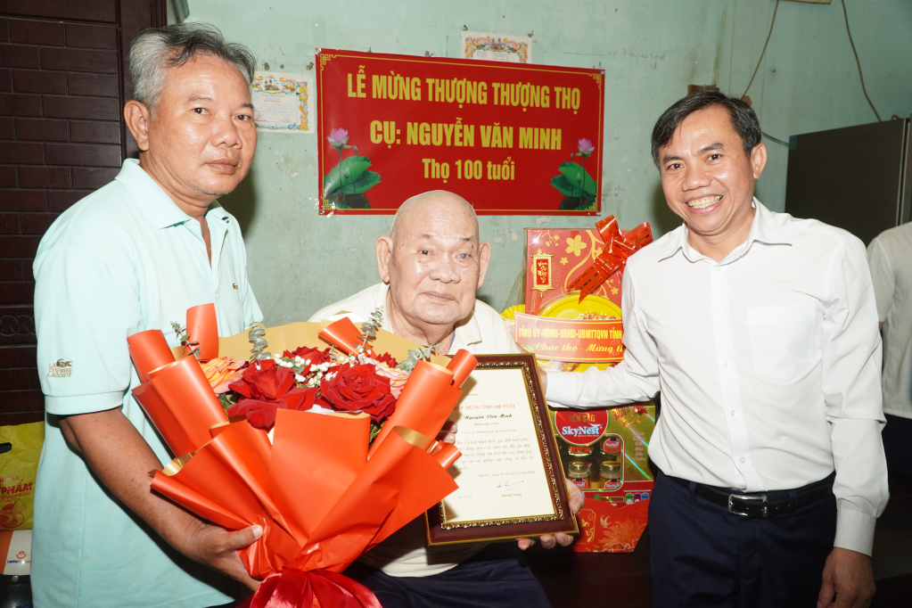 Ủy viên Ban Thường vụ Tỉnh ủy, Bí thư Đảng ủy phường Long An Lê Công Đỉnh (bìa phải) thăm, tặng quà và chúc thọ cụ Nguyễn Văn Minh tròn 100 tuổi