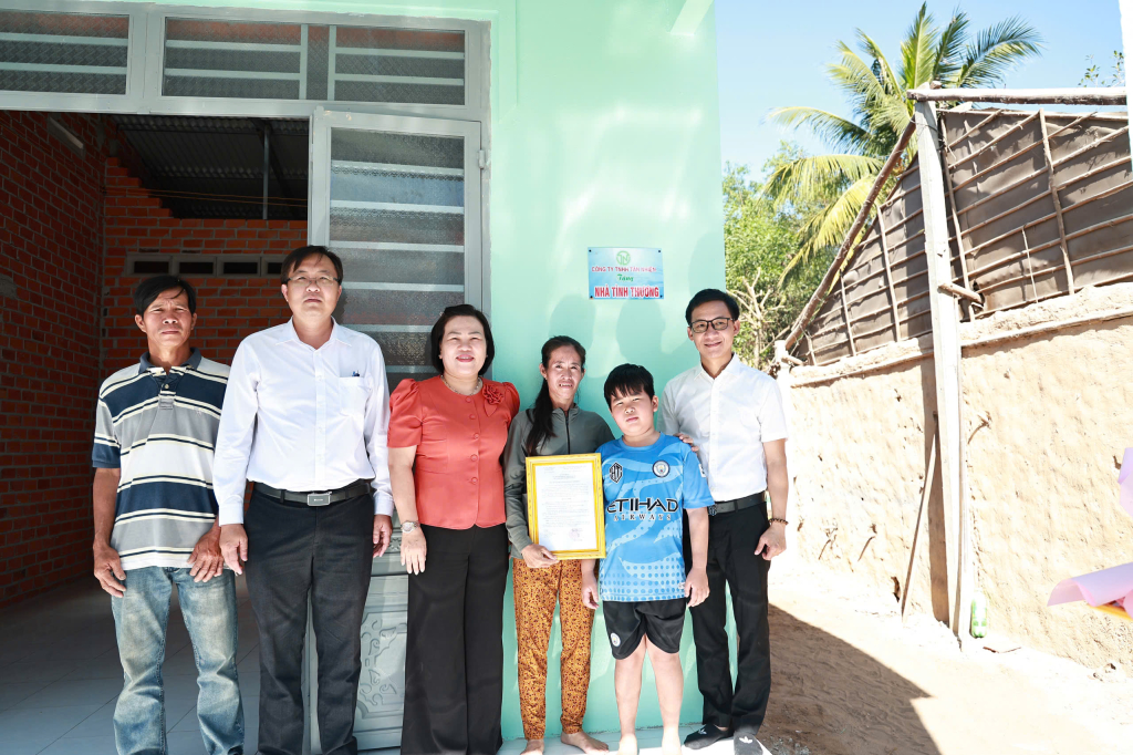 Bí thư Đảng ủy, Chủ tịch HĐND xã Ninh Điền Trần Thị Ngọc Nương (giữa) trao nhà cho gia đình bà Nguyễn Thị Kim Thoa