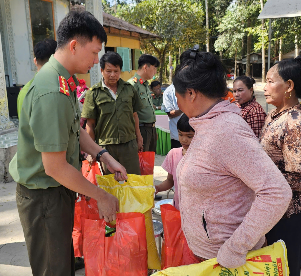 Đại úy Văn Công Chiến - Bí thư Chi đoàn cơ sở Phòng An ninh nội địa - Quản lý xuất nhập cảnh, Công an tỉnh Tây Ninh (bìa trái) trao quà cho người dân