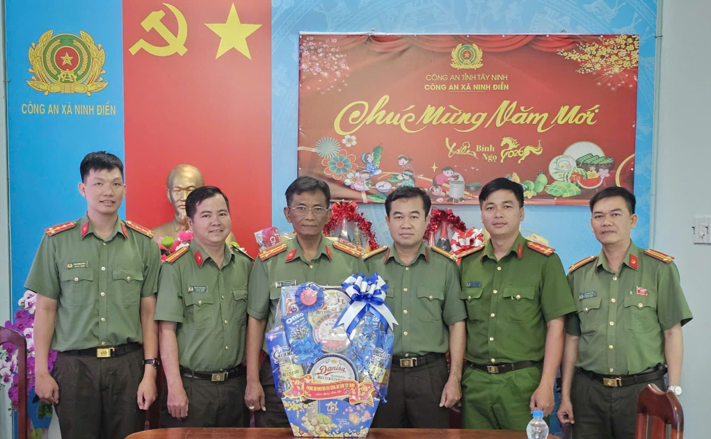 Thượng tá Trần Minh Đông - Phó Trưởng phòng An ninh nội địa, Công an tỉnh Tây Ninh (thứ ba, từ trái qua) trao quà Tết cho Công an xã Ninh Điền
