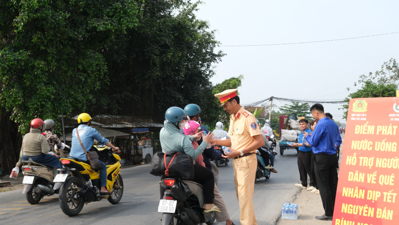 Cảnh s&aacute;t giao th&ocirc;ng tặng nước uống cho người d&acirc;n về qu&ecirc; tr&ecirc;n tuyến Quốc lộ N2