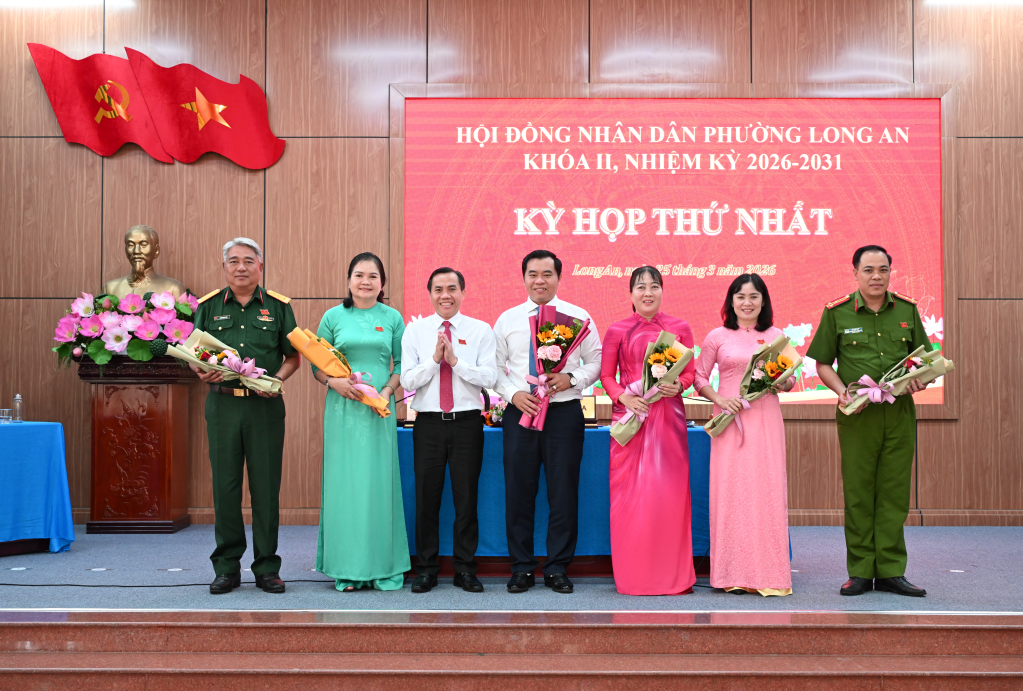 Ủy viên Ban Thường vụ Tỉnh ủy, Bí thư Đảng ủy, Chủ tịch HĐND phường Long An Lê Công Đỉnh tặng hoa chúc mừng các đồng chí được bầu giữ chức vụ chủ chốt của UBND phường