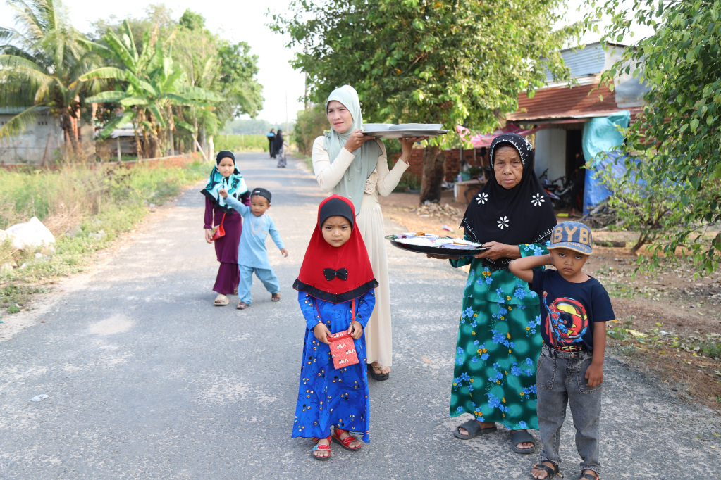 Các chị phụ nữ mang thức ăn là món cà ri lên Thánh đường 