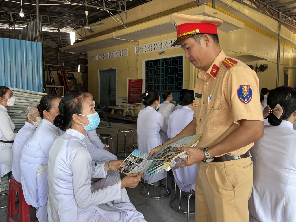 Cán bộ phát tờ rơi tuyên truyền pháp luật cho tín đồ tôn giáo Cao đài